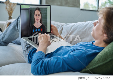 Teenage guy student having online lesson, watching webinar, at home Teenage guy student having online lesson, watching webinar, at home 132578862