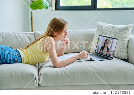 Teenage girl student having online lesson, watching webinar, at home Teenage girl student having online lesson, watching webinar, at home 132578881