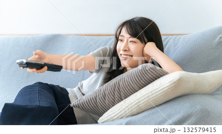 ソファに寝転んでテレビを見る女性 ソファに寝転んでテレビを見る女性 132579415