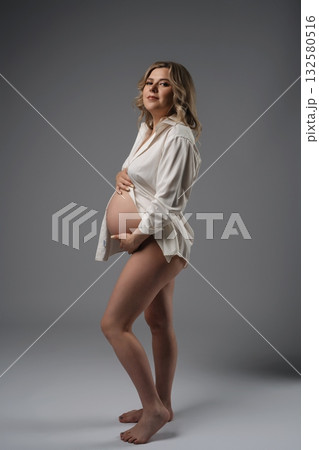 Pregnant Woman In White Shirt Studio Portrait 132580516