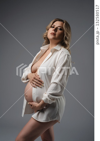 Pregnant Woman in White Shirt Studio Portrait 132580517