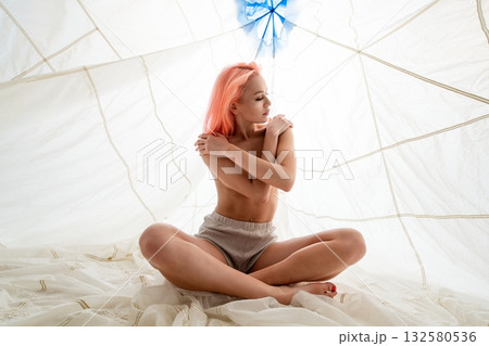 Woman With Pink Hair Sitting in a White Tent 132580536