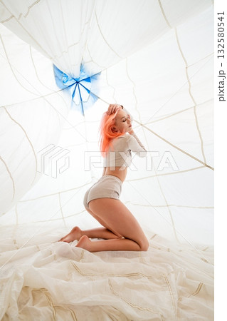 Woman With Pink Hair Kneeling Under White Canopy 132580541
