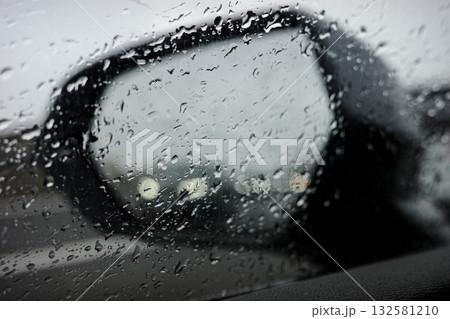 Car side mirror on a rainy day with water droplets on glass Car side mirror on a rainy day with water droplets on glass 132581210