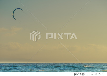 Kite surfer riding waves. Kiteboarding sport. 132581598