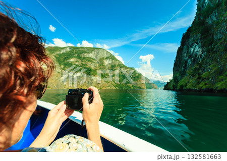 Tourism. Woman with camera on ship, fjord in Norway. 132581663