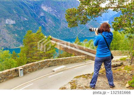 Tourist taking photo from Stegastein viewpoint Norway Tourist taking photo from Stegastein viewpoint Norway 132581666