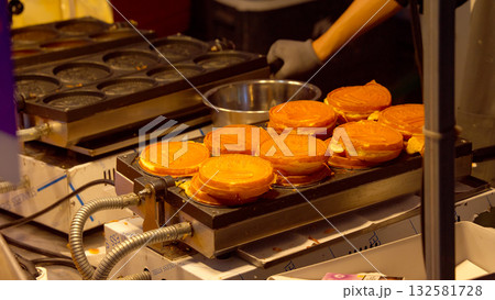 Seoul street food vendor preparing Korean waffles at night 132581728