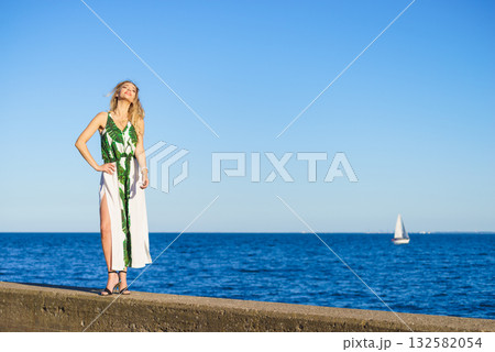 Woman in summer long dress against sea 132582054