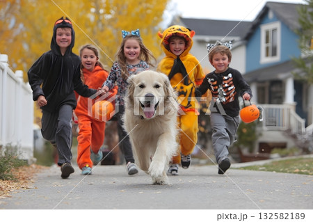 Children and dog run together for Halloween in their costumes with treats. 132582189