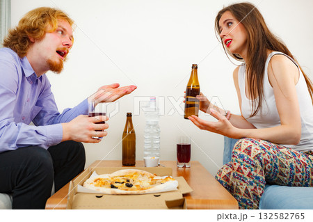 Couple eating pizza and drinking beer Couple eating pizza and drinking beer 132582765