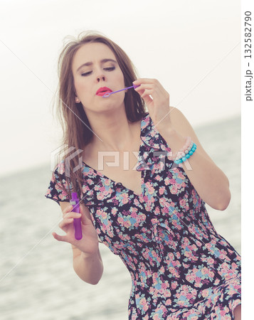 Woman blowing bubbles outdoor Woman blowing bubbles outdoor 132582790