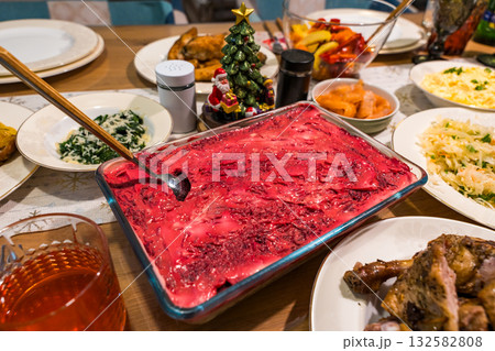 Traditional festive table with herring under a fur coat salad and homemade holiday dishes Traditional festive table with herring under a fur coat salad and homemade holiday dishes 132582808