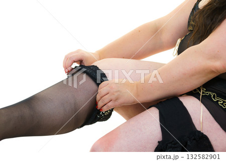 Woman plus size puts on black nylon stockings 132582901