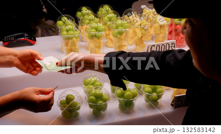 Buying fresh fruit cups at Seoul street market 132583142