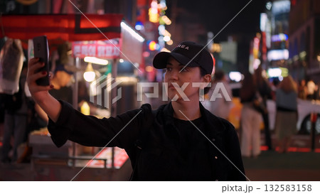 Woman taking selfie in Seoul city street at night 132583158