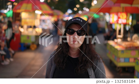 Woman wearing Korea hat enjoying Busan night market street food Woman wearing Korea hat enjoying Busan night market street food 132583184