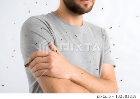 Mosquitoes swarm around a person scratching their arm. 132583819