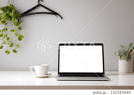 A laptop sits open on a desk with a plant and coffee. A laptop sits open on a desk with a plant and coffee. 132583840