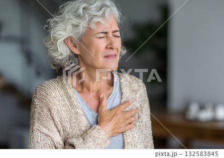 Woman holds chest feeling pain. Woman holds chest feeling pain. 132583845