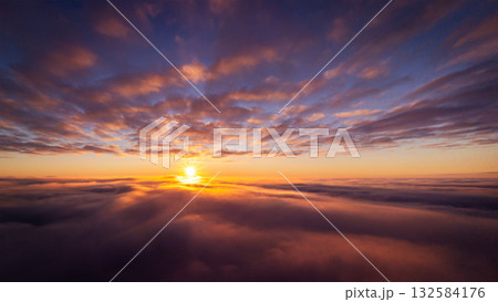 Drone photo of setting sun above clouds in the sky. Dramatic drone photo flying high in the clouds 132584176
