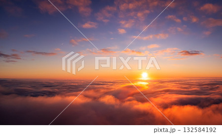 Spectacular aerial photo of setting sun above the clouds. Flying on plane in the evening and witnessing dramatic view of sun going under horizon Spectacular aerial photo of setting sun above the clouds. Flying on plane in the evening and witnessing dramatic view of sun going under horizon 132584192