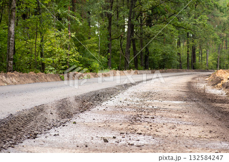 Making new asphalt road in the countryside. One lane is ready while the other one needs a finishing layer on top 132584247
