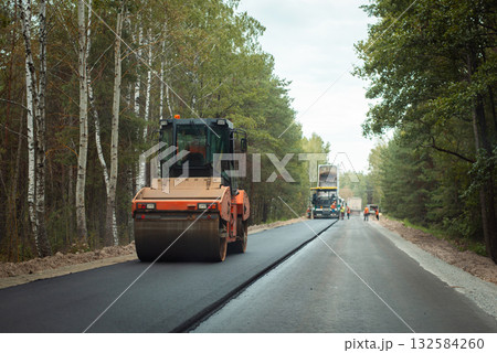 Road roller thickening just made new asphalt lane. Road construction in the countryside Road roller thickening just made new asphalt lane. Road construction in the countryside 132584260