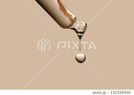 Serum in a pipette close-up on a beige background. 132584400