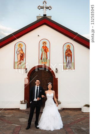 Interracial couple celebrating wedding outside orthodox church 132585045