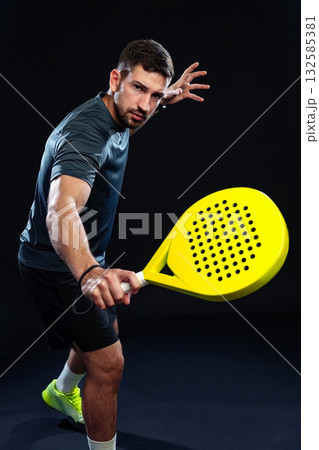 Man playing with a yellow paddle in an indoor sports arena during a night session Man playing with a yellow paddle in an indoor sports arena during a night session 132585381