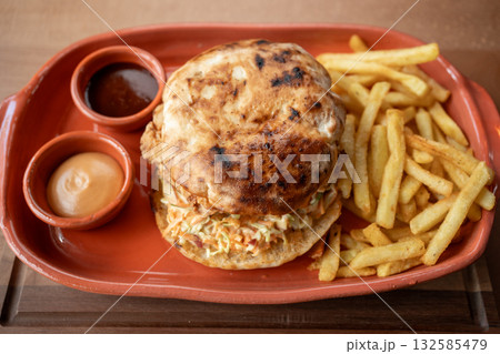Savory sandwich and crispy fries served on a rustic plate for lunch Savory sandwich and crispy fries served on a rustic plate for lunch 132585479