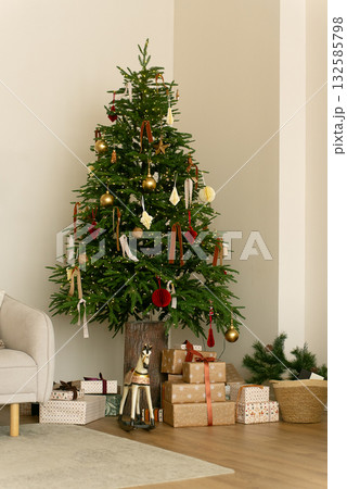 Cozy Christmas tree with gifts and wooden horse. Ample copy space for text. Ideal holiday background for social media, email, and e-commerce. Christmas background Cozy Christmas tree with gifts and wooden horse. Ample copy space for text. Ideal holiday background for social media, email, and e-commerce. Christmas background 132585798