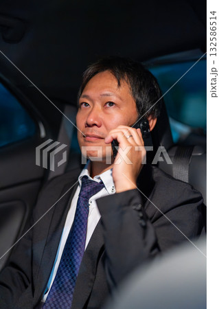 後部座席で緊急のビジネスコールに応じる男性 後部座席で緊急のビジネスコールに応じる男性 132586514