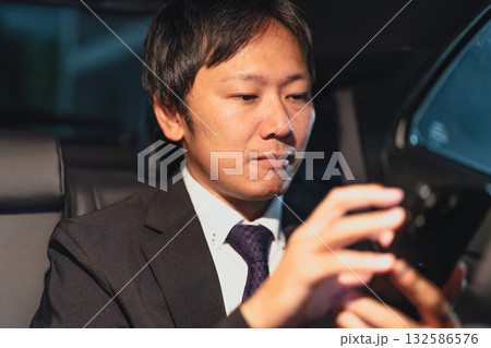 客先移動中にスマートフォンで連絡を取るビジネスマン 132586576