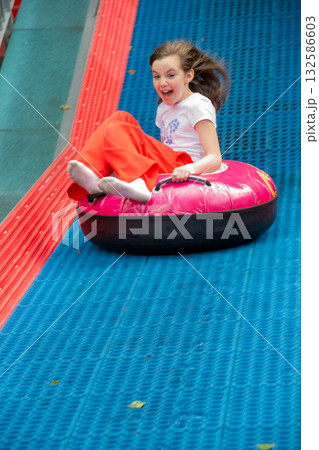 Kids having fun in ferris wheel with chains, carousel ski flyer in amusement park in Targoviste, Romania, 2020. High quality photo 132586603
