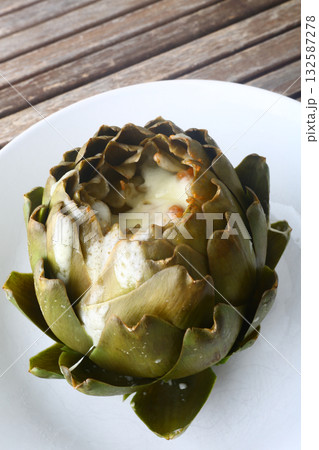 cooked seasonal artichoke with cheese and sobrasada 132587278