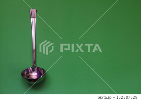 metal soup ladle on a green background 132587329