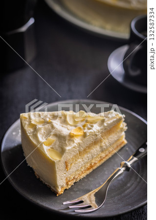 Sweet creamy cake on plate on black table. 132587334