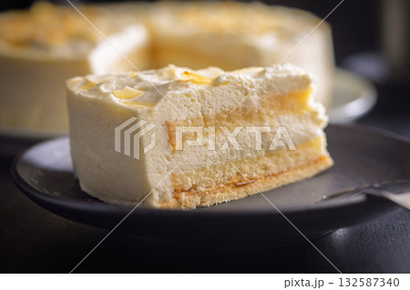 Sweet creamy cake on plate on black table. Sweet creamy cake on plate on black table. 132587340