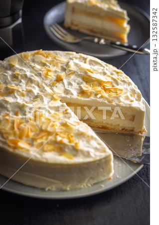 Sweet creamy cake on plate on black table. 132587342