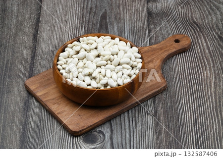 white kidney bean in wooden bowl isolated on wooden background. Top view. Flat lay 132587406