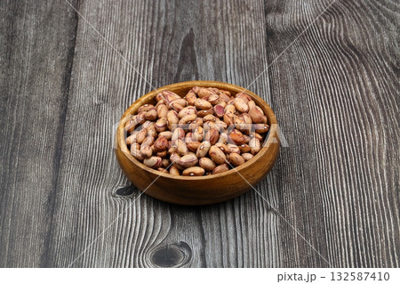 red kidney beans in wooden bowl isolated on dark background. red kidney beans in wooden bowl isolated on dark background. 132587410