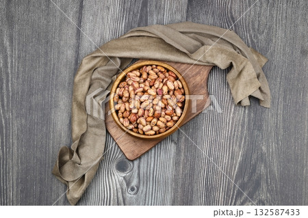 red kidney beans in wooden bowl isolated on dark background. red kidney beans in wooden bowl isolated on dark background. 132587433