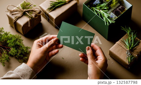 A person holding a green business card in front of a bunch of presents A person holding a green business card in front of a bunch of presents 132587798