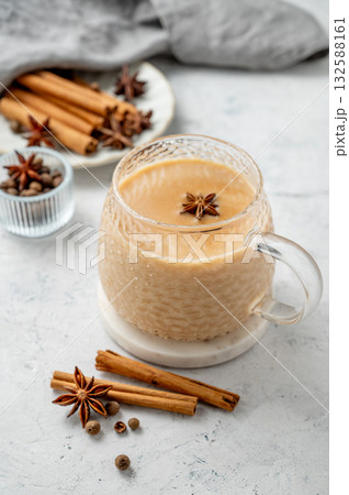 Traditional Indian masala chai tea with milk and spices in a cup on a light background with cinnamon Traditional Indian masala chai tea with milk and spices in a cup on a light background with cinnamon 132588161