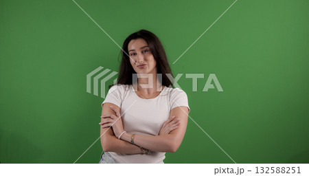 Confident young woman crossing arms on green screen background 132588251