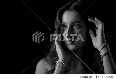 Young Woman Touching Hair and Looking Away in Black and White Portrait Young Woman Touching Hair and Looking Away in Black and White Portrait 132588806