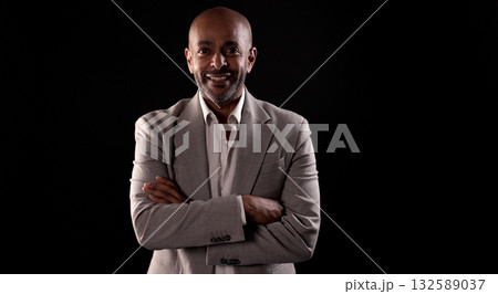 Smiling african american businessman crossing arms on black background 132589037