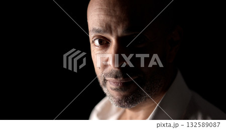 Confident african american businessman posing in dark room Confident african american businessman posing in dark room 132589087
